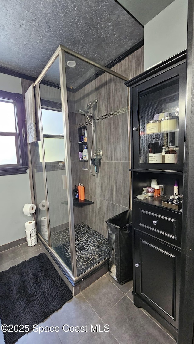 bathroom featuring tile patterned floors and a shower with door