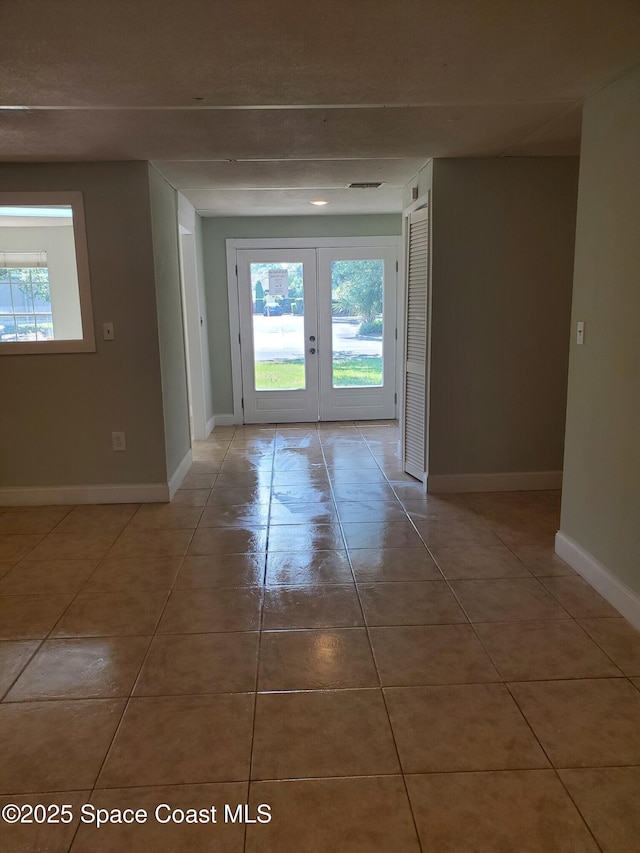 interior space with tile patterned floors and french doors