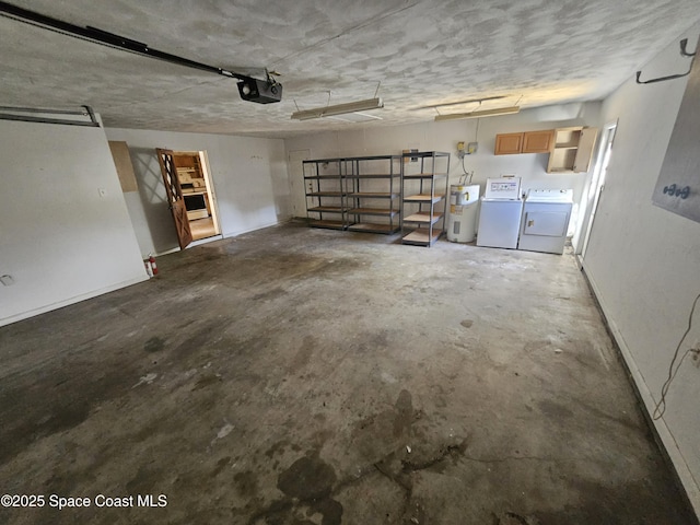 garage with baseboards, washing machine and dryer, electric water heater, and a garage door opener