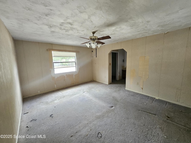 spare room featuring ceiling fan and arched walkways