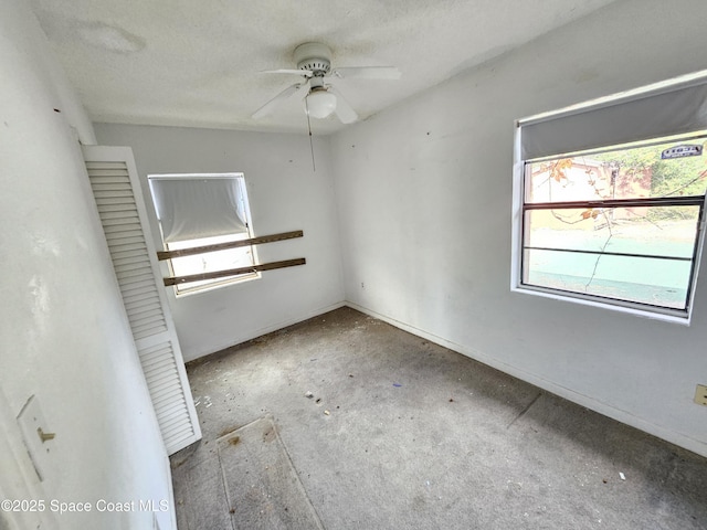 spare room featuring a textured ceiling and ceiling fan