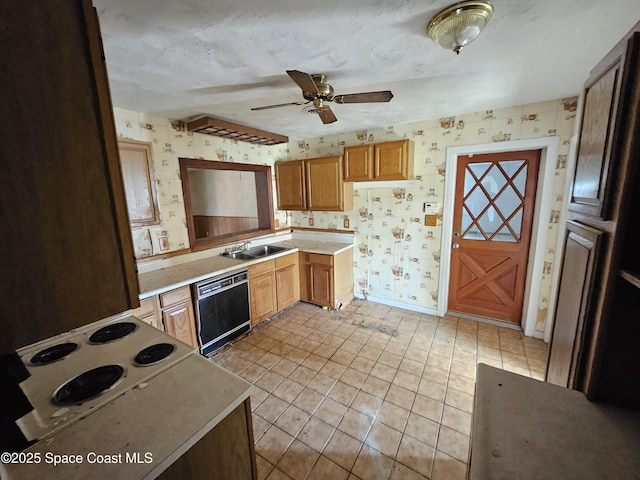 kitchen featuring light countertops, ceiling fan, a sink, dishwasher, and wallpapered walls