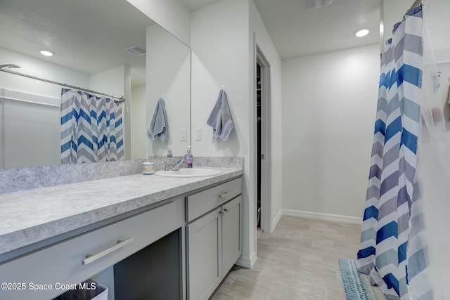 bathroom featuring walk in shower and vanity