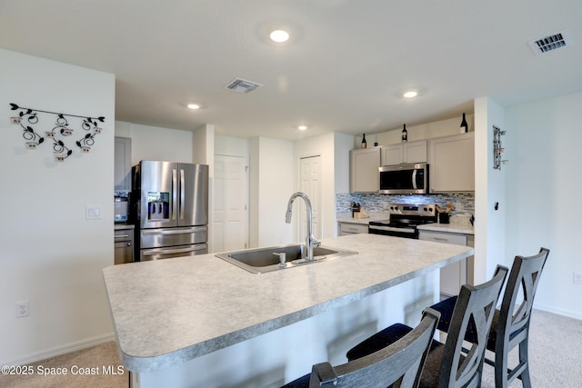 kitchen featuring sink, gray cabinetry, stainless steel appliances, and a kitchen island with sink