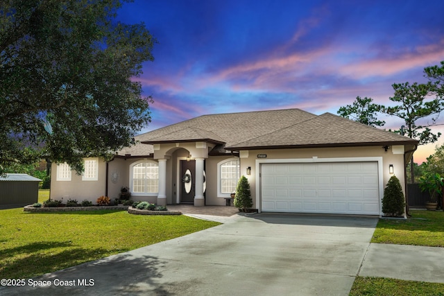 view of front of property with a garage and a yard