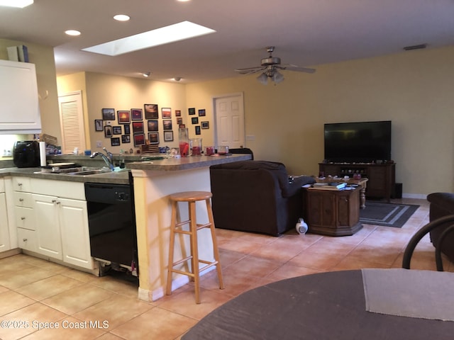 kitchen featuring white cabinetry, black dishwasher, light tile patterned flooring, and kitchen peninsula