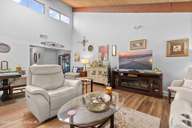 living room with wood-type flooring, wood ceiling, and a towering ceiling