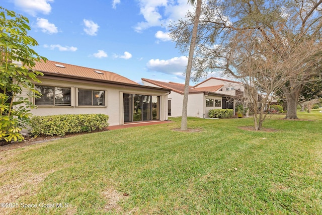 rear view of property featuring a lawn