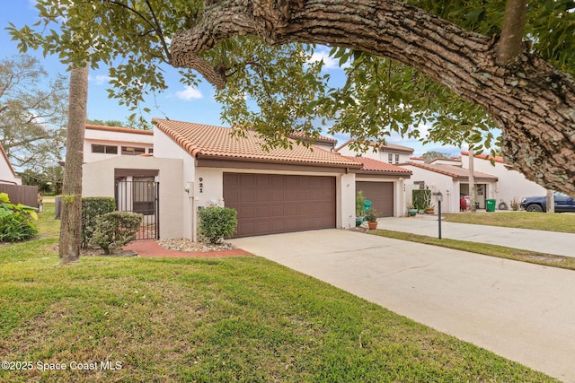 mediterranean / spanish house featuring a front yard and a garage