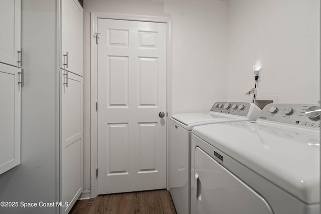 laundry area with cabinets, washing machine and dryer, and dark hardwood / wood-style floors