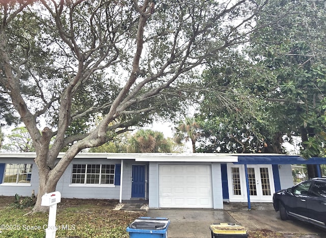 single story home featuring a garage and french doors