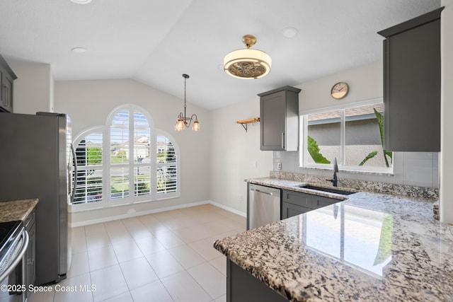 kitchen with lofted ceiling, sink, pendant lighting, stainless steel appliances, and light stone countertops