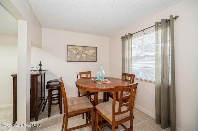 tiled dining area with a textured ceiling