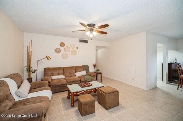 living room with ceiling fan and a textured ceiling