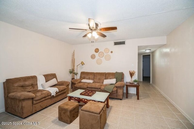 living room featuring ceiling fan and a textured ceiling