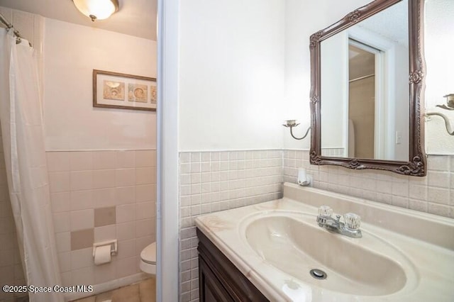 bathroom featuring tile walls, vanity, tile patterned flooring, and toilet