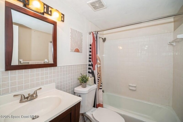 full bathroom featuring vanity, tile walls, shower / tub combo with curtain, and toilet