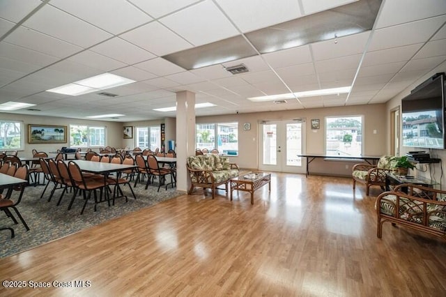 dining space with hardwood / wood-style flooring, a paneled ceiling, and french doors