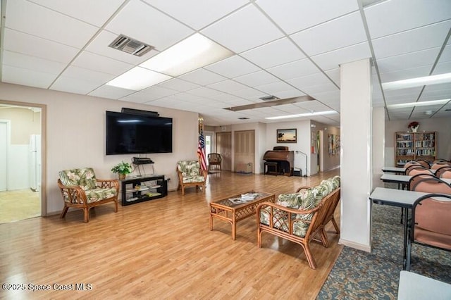 living room with wood-type flooring and a paneled ceiling