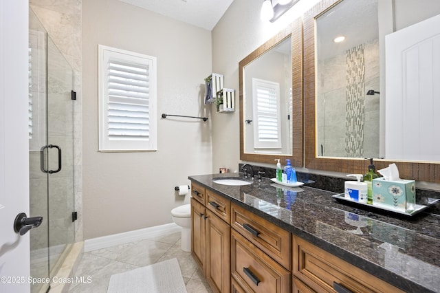 bathroom featuring tile patterned flooring, vanity, toilet, and a shower with shower door