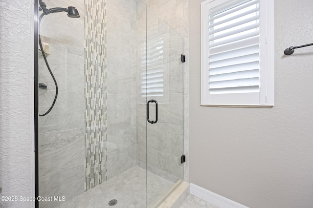 bathroom featuring a shower with door