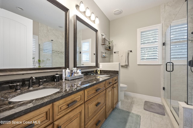 bathroom with plenty of natural light, toilet, a shower with door, and vanity