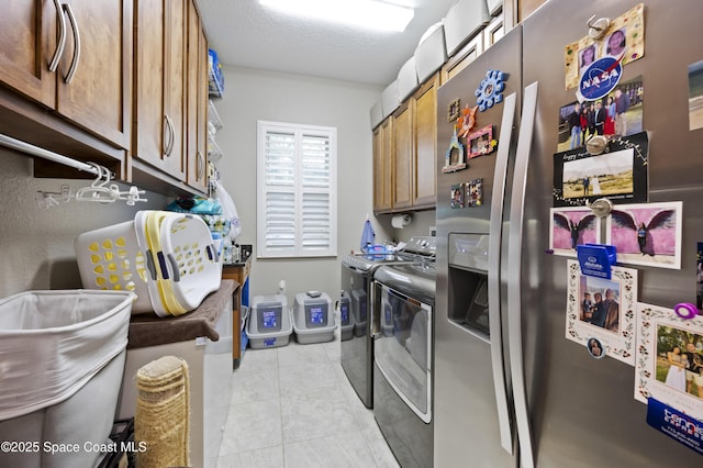 laundry area featuring cabinets, washer and dryer, and a textured ceiling