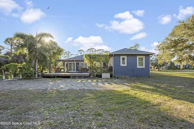 rear view of property with a yard and a deck