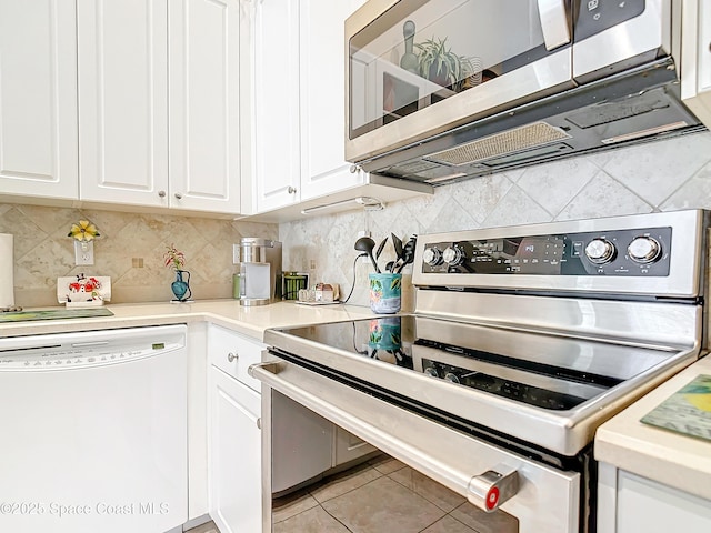 kitchen featuring tasteful backsplash, light tile patterned floors, stainless steel appliances, and white cabinets