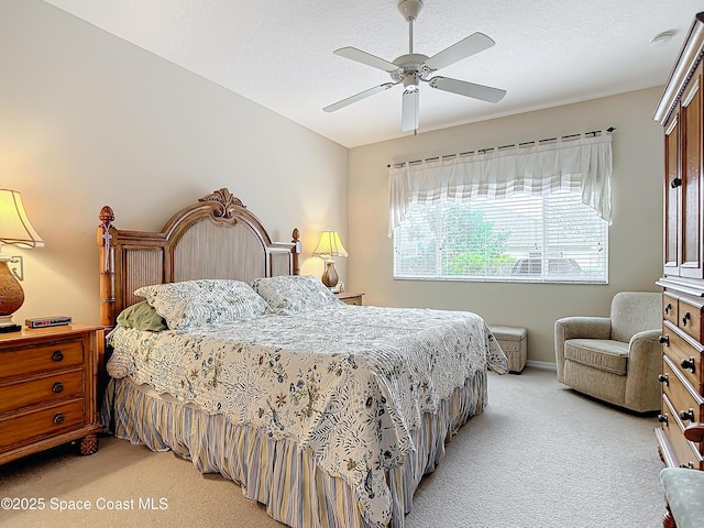 bedroom featuring light carpet, a textured ceiling, and ceiling fan