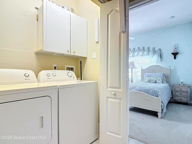 laundry area with light carpet, cabinets, and washing machine and clothes dryer