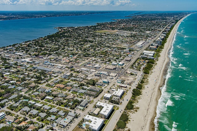 birds eye view of property with a water view and a beach view