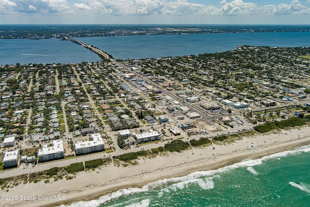 birds eye view of property with a water view and a beach view