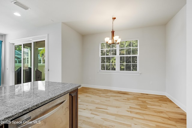 interior space featuring a notable chandelier, plenty of natural light, and light wood-type flooring