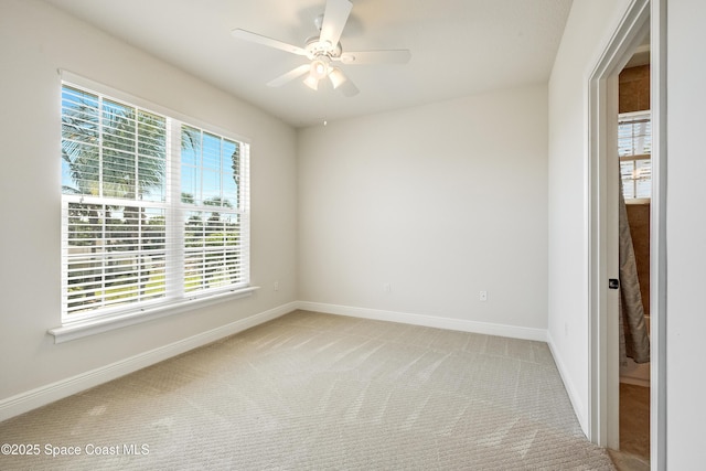 empty room featuring ceiling fan and light colored carpet