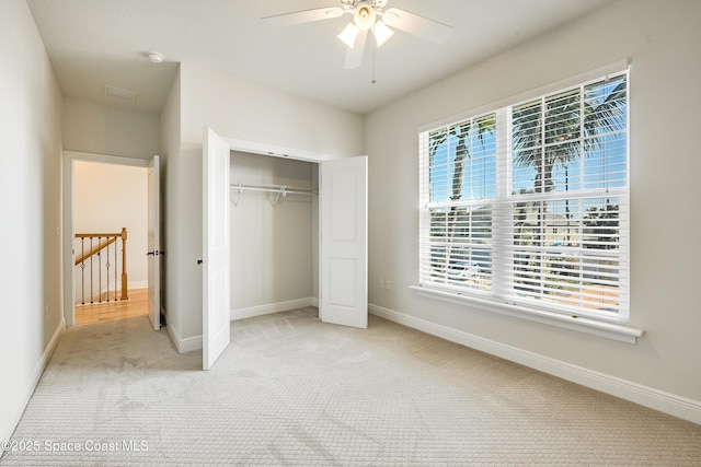 unfurnished bedroom with light colored carpet and a closet