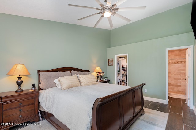 bedroom featuring connected bathroom, a walk in closet, a closet, and ceiling fan