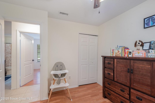 bedroom with light hardwood / wood-style flooring, a closet, and ceiling fan