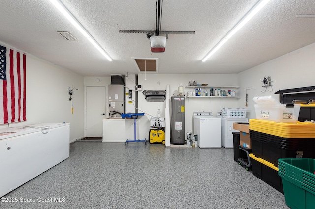 garage featuring water heater, a garage door opener, heating unit, and independent washer and dryer