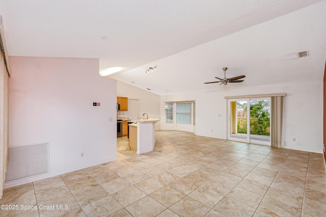 unfurnished living room with ceiling fan, sink, and vaulted ceiling