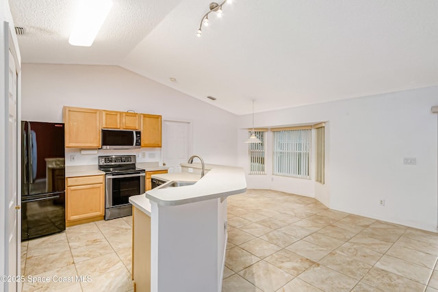 kitchen featuring lofted ceiling, sink, pendant lighting, appliances with stainless steel finishes, and a textured ceiling