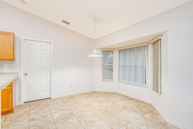 unfurnished dining area featuring vaulted ceiling