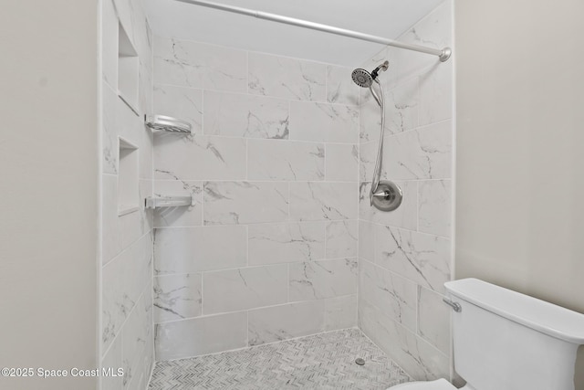 bathroom with tiled shower and toilet