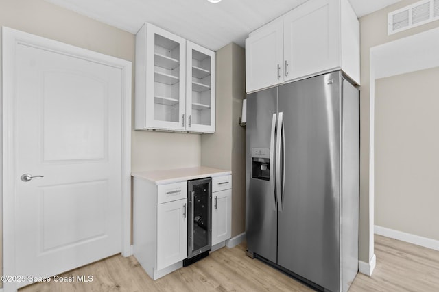 kitchen featuring white cabinetry, stainless steel fridge with ice dispenser, wine cooler, and light hardwood / wood-style flooring