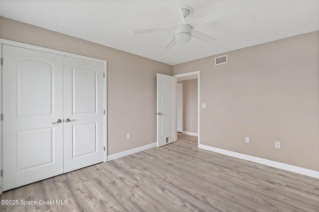 unfurnished bedroom featuring ceiling fan, a closet, and light wood-type flooring