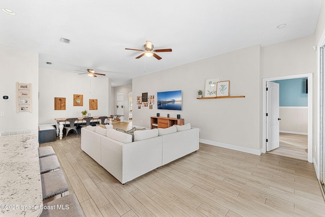 living room featuring ceiling fan and light hardwood / wood-style floors