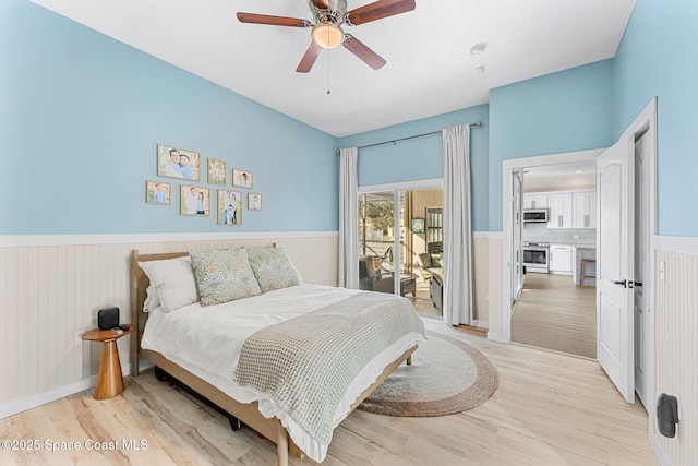 bedroom featuring light wood-type flooring, ceiling fan, access to exterior, and a textured ceiling