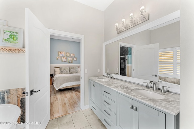 bathroom with a washtub, tile patterned floors, and vanity