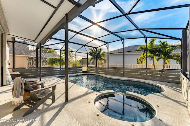 view of swimming pool with a patio area, glass enclosure, and an in ground hot tub