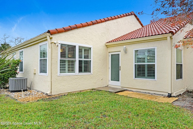 rear view of property featuring central AC and a yard